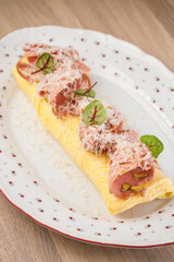 Savory omelet topped with ham and herbs served