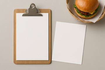 Burger and Menu: A tantalizing overhead shot features a freshly prepared burger alongside a blank clipboard, poised on a seamless light-tone surface, ready for menu additions.