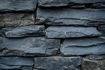 A wall made of blue stone blocks. Dark blue slate rock texture background with rough cracked layers of stone.