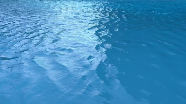 Rippling blue water surface on light blue background. Filmed on high speed cinema camera, 1000 fps.