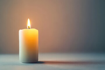 White candle isolated on white background. Candle is lit on a table. The candle is the only object in the image, and it is the only source of light.