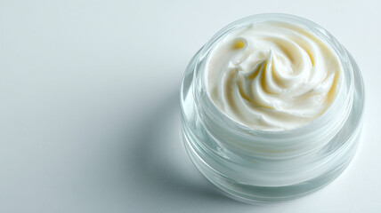 A jar of creamy, swirling skincare product is presented against a clean, simple backdrop.