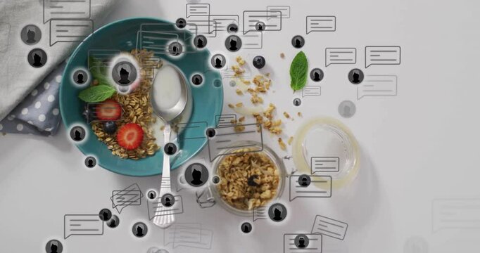 Drifting speech bubbles and user icons spiraling over teal bowl showing digital chat over breakfast