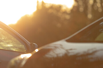 Two stunning cars are captured against a breathtaking sunset, with sunlight flaring around them,...