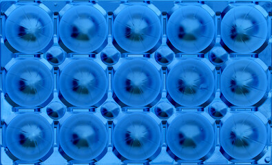 A pattern of blue pressed in spherical elements arranged in even rows
