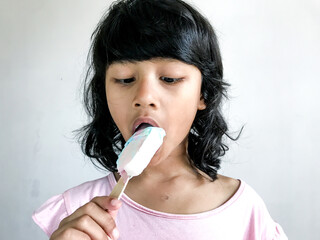 A little girl is eating an ice cream