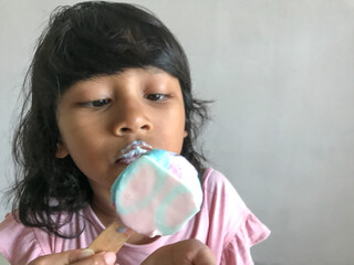 A little girl is eating an ice cream