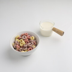 Colorful cereal served with milk on white background 