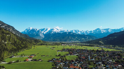 Lush countryside with red rooftops and mountains