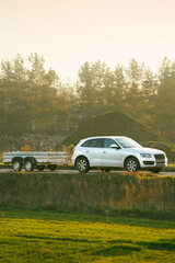 Fototapeta premium Minivan and trailer traveling through countryside