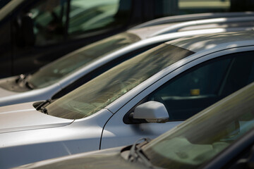 Fototapeta premium In a designated parking area, there are several parked silver cars that have dirty windshields, which illustrates the importance of proper automobile storage and regular vehicle maintenance
