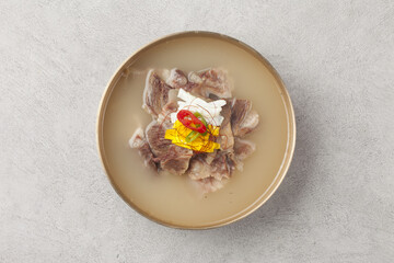  A dish of rice cooked in a soup made with beef head meat, bones, radish, and other vegetables.   
