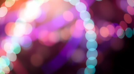 A dark background with an abstract pattern of blurred lights in various shades of pink, purple, blue, and green