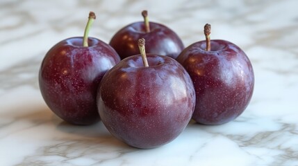 Close-up Arrangement of Fresh Plums Displaying Deep Purple Hues and Delicate Stems on Marble Countertop