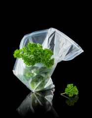 Fresh parsley packed in a clear plastic bag ready for sale at the market showcasing vibrant green colors