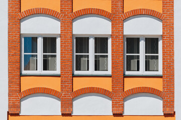 Symmetrical Orange-Brick Window Facade with Arched Accents