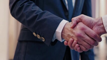 Close-up of a handshake between two businessmen in formal attire - Powered by Adobe