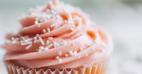 Close-up of a delicious cupcake with pink frosting and white sprinkles. A sweet treat for a special occasion or everyday indulgence.