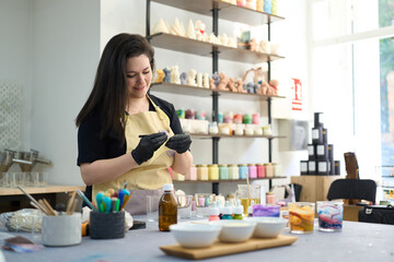 Woman making handmade colorful candles in craft studio