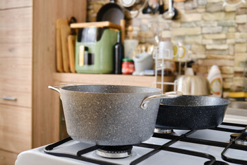 Cooking utensils on a stove in a modern kitchen with stylish decor and natural elements