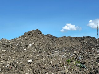 A large dirt mound on a construction site, showcasing raw earth and rugged terrain, ideal for themes of excavation, land development, or natural landscapes.