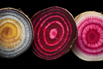 Three slices of onion are cut in half and arranged in a row. The slices are different colors, with one being yellow, one being white, and one being pink. The arrangement creates a visually interesting