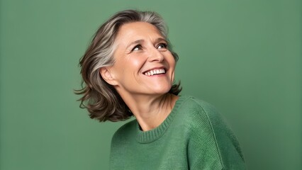 Portrait of beautiful senior woman with short white hair smiling at camera. Happy mature female on green background. Cheerful lady in 60s, 70s. Portrait of elderly woman. Beauty, natural beauty