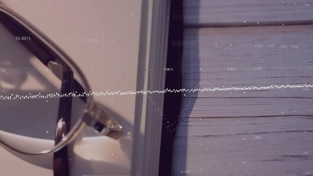 Upon audio playback waveform rising into peaks subsiding above glasses on book illustrating sound