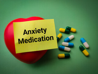 Red heart and sticky note with the word Anxiety Medication on a green background