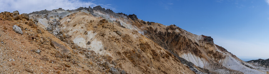 Panorama shot of blue sky and active volcano Mt.Esan with spewing smoke in Hakodate Hokkaido, Japan