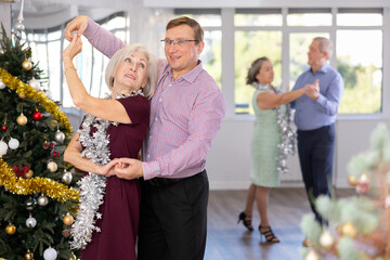 Adult man and elderly woman dance ballroom dance waltz in studio