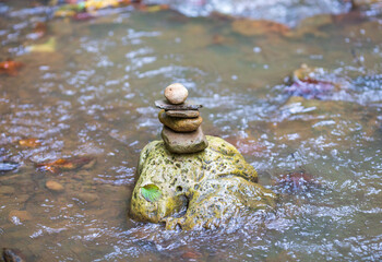 stone figurines in the riverbed , an autumn day on a shallow river in nature