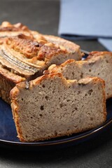 Cut banana bread with nuts on black table, closeup