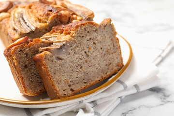 Cut banana bread with nuts on white marble table, closeup