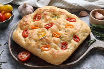 Delicious focaccia with tomatoes and spices on table, closeup