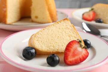 Piece of tasty bundt cake with berries on table, closeup
