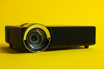 Modern video projector on yellow background, closeup