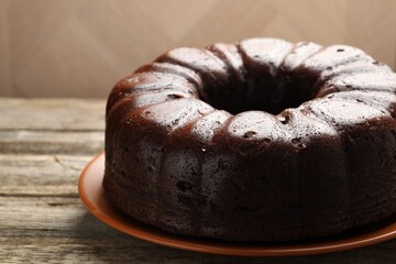 Tasty chocolate bundt cake on wooden table, closeup