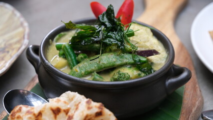 Thailand green curry on a black bowl.
