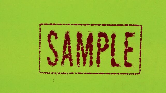 Close-up of a red ink stamp sign that reads SAMPLE on a green background.