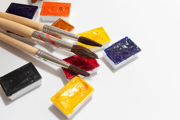 A vibrant color palette of watercolor paints with artist brushes that showcase a variety of shades and textures, perfect for art projects and creative expression