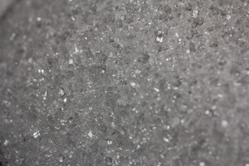 Textured gray surface with shimmering crystals, an abstract mineral background concept
