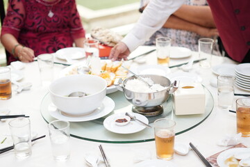 A restaurant waiter serving food at a round table to event guests for lunch