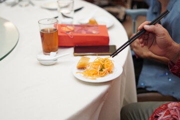 A person picking up jellyfish salad with chopsticks at a Chinese event