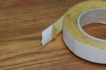 White double sided tape on wood background with copy space.Close up.
