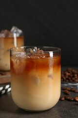 Tasty iced coffee and beans on grey table, closeup