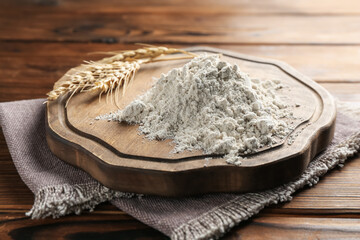 Pile of flour and spikes on wooden table, closeup