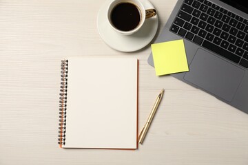 Notebook, pen, sticky note, coffee and laptop on wooden table, flat lay