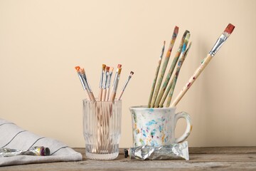 Brush with color paints on wooden table