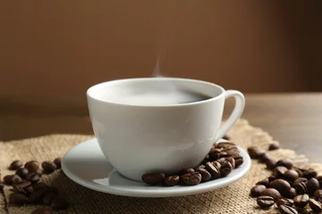 Fototapete Rund Aromatic coffee in cup and beans on table, closeup © New Africa